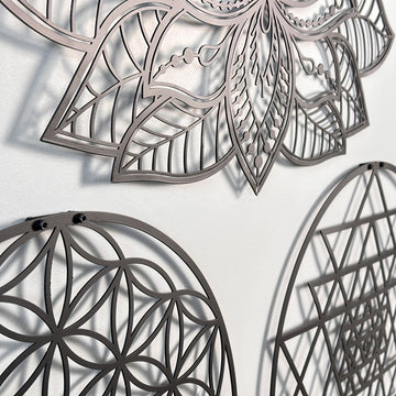 Siyah metal Mandala yaprakları ve Yaşam Çiçeği halkasının duvardaki gölgeli detay çekimi