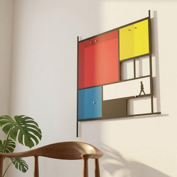 Mondrian tarzı renk bloklu metal tablo, ahşap sandalye ve bitkinin yanında beyaz duvarda