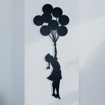 Banksy Balonlu Kız metal tablonun yakın çekimi, siyah balonlar ve el uzatan kız figürü