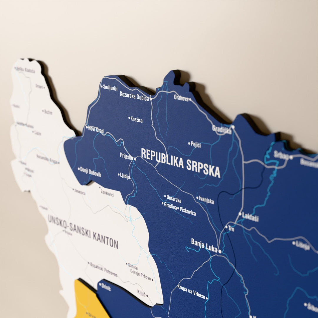 Bosna-Hersek ahşap haritasında bayrak renkli katmanlı bölgeler ve isimler, yakın plan