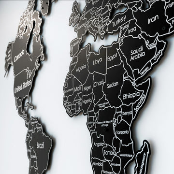 Siyah metal dünya haritası yan açıdan yakın çekim, Afrika ve Orta Doğu ülkeleri ile duvara yansıyan gölge