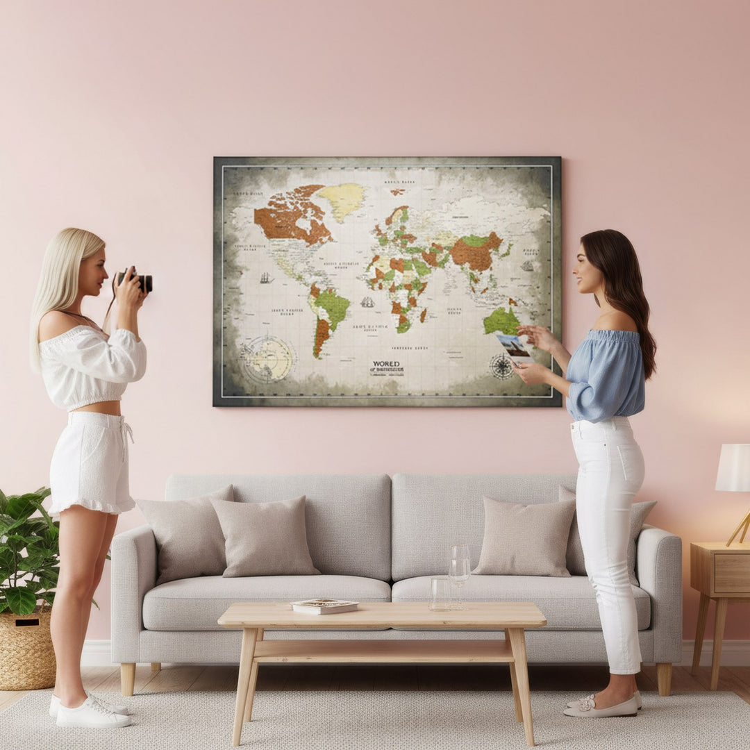 sepya yesil ve bej tonlarinda kanvas dunya haritasi tablonun onunda fotograf ceken iki kadin colorfullworldstr