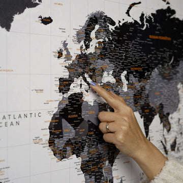 Monochrome dünya haritası kanvas tabloda Avrupa ve Afrika bölgesine parmakla işaret, yakın çekim