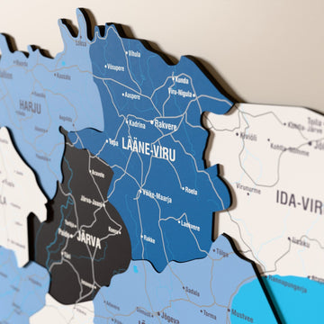 Estonya ahşap haritasında bayrak renkli katmanlı bölgeler ve isimler, yakın plan