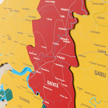 Gine-Bissau ahşap haritasında bayrak renkli katmanlı bölgeler ve isimler, yakın plan