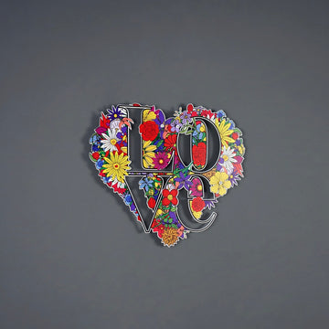 Çiçek desenli kalp şeklinde LOVE metal tablo, gri duvarın ortasında