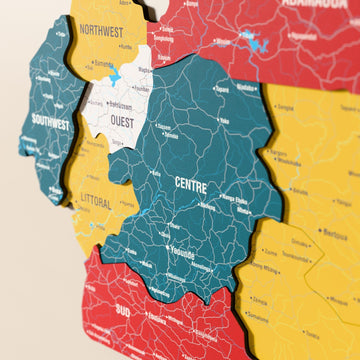 Kamerun ahşap haritasında bayrak renkli katmanlı bölgeler ve isimler, yakın plan