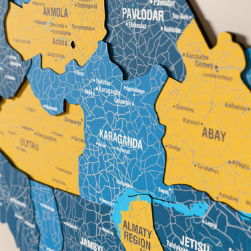 Kazakistan ahşap haritasında bayrak renkli katmanlı bölgeler ve isimler, yakın plan