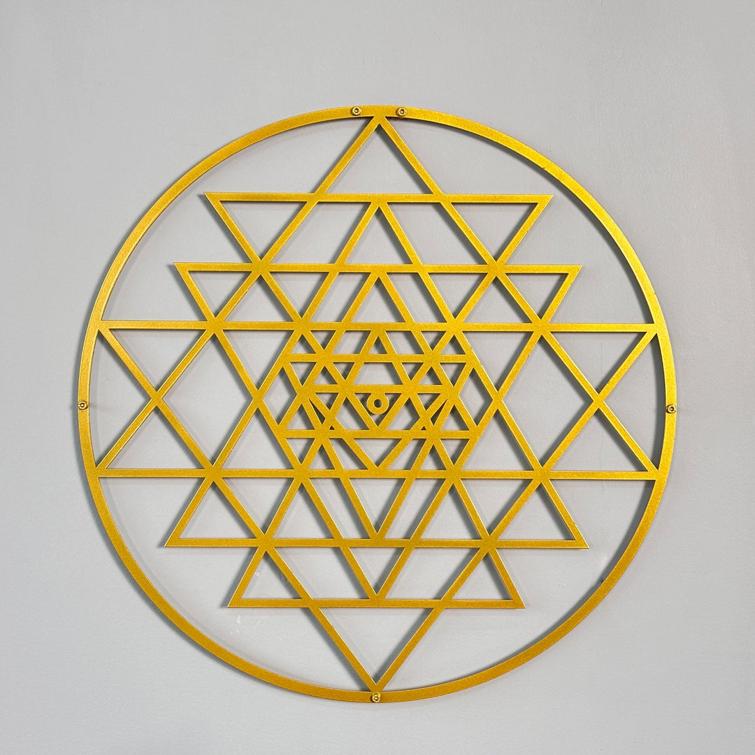 Altın renkli daire Sri Yantra metal duvar tablosu, gri duvarda önden tam görünüm