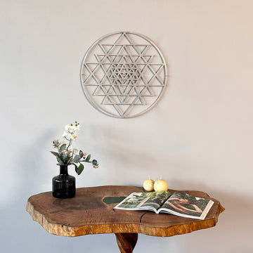 Gümüş Sri Yantra kutsal geometri metal duvar tablosu, ahşap konsolun üzerindeki duvarda