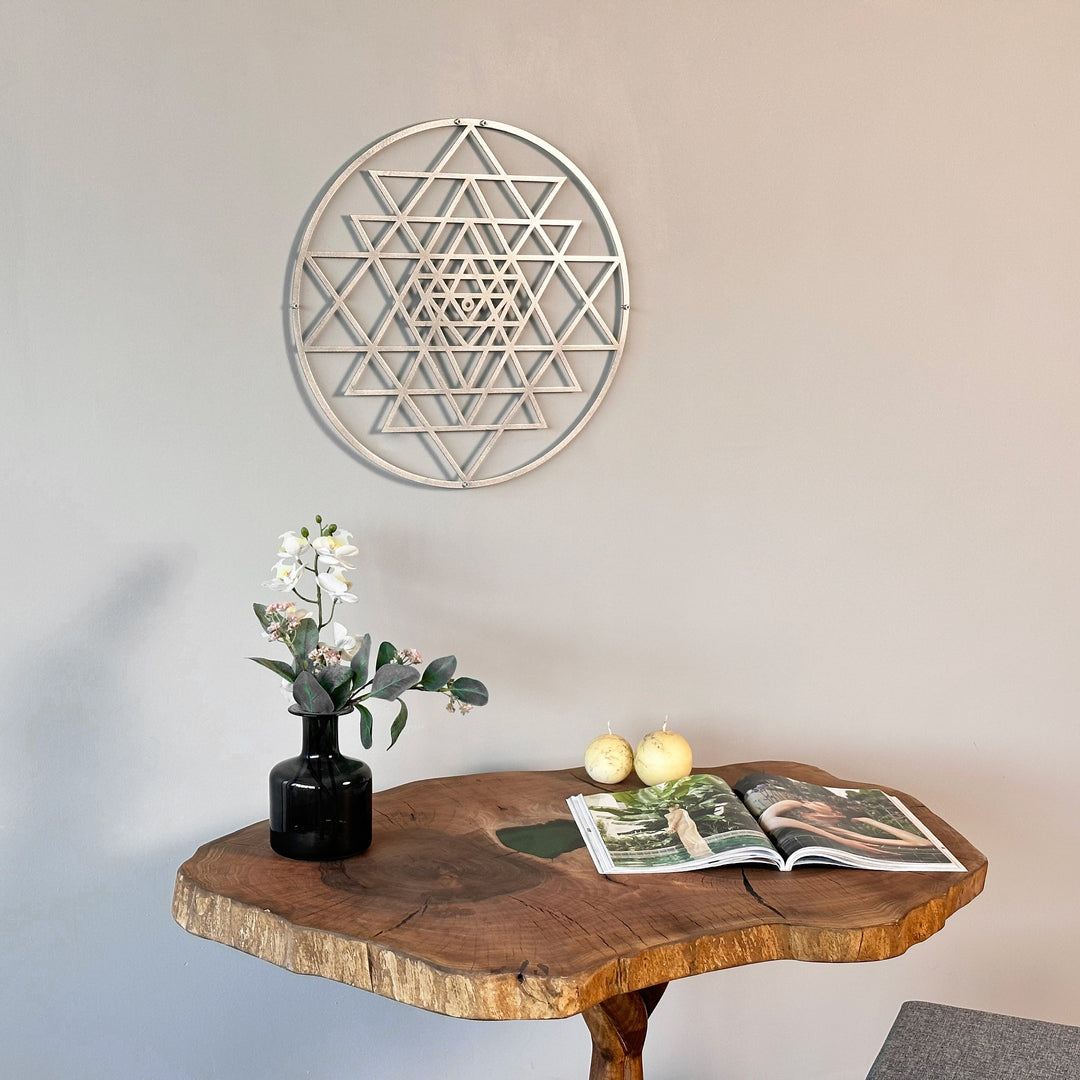 Gümüş Sri Yantra metal tablo, konsolun üzerindeki duvarda, çiçek vazosu yanında yakın oda planı