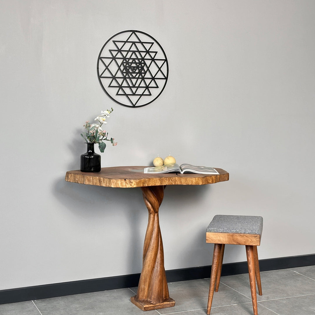 Siyah Sri Yantra metal duvar tablosu, ahşap konsol ve gri tabureli geniş plan