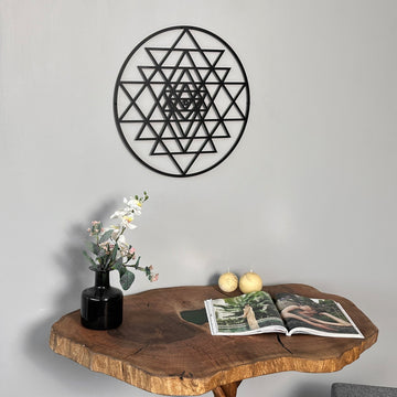 Siyah Sri Yantra metal tablo, konsolun üzerindeki duvarda, çiçek vazosu yanında yakın oda planı