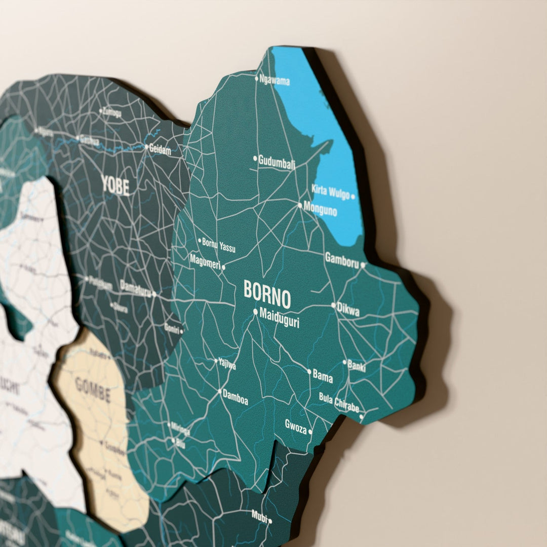 Nijerya ahşap haritasında bayrak renkli katmanlı bölgeler ve isimler, yakın plan
