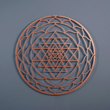 Bakır renkli daire Sri Yantra metal duvar tablosu, koyu gri duvarda önden görünüm