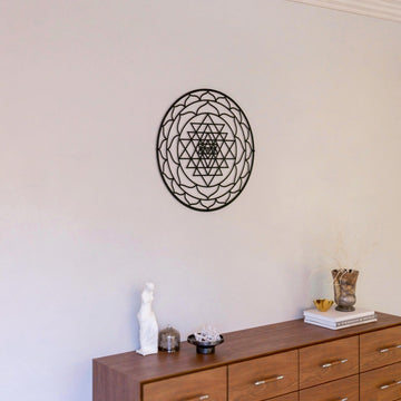 Siyah Sri Yantra metal duvar tablosu, konsolun üzerindeki beyaz duvarda uzak oda planı