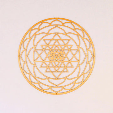 Altın renkli daire Sri Yantra metal duvar tablosu, açık duvarda önden görünüm