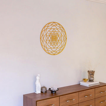 Altın Sri Yantra metal duvar tablosu, ahşap çekmeceli konsolun üzerindeki duvarda geniş oda planı