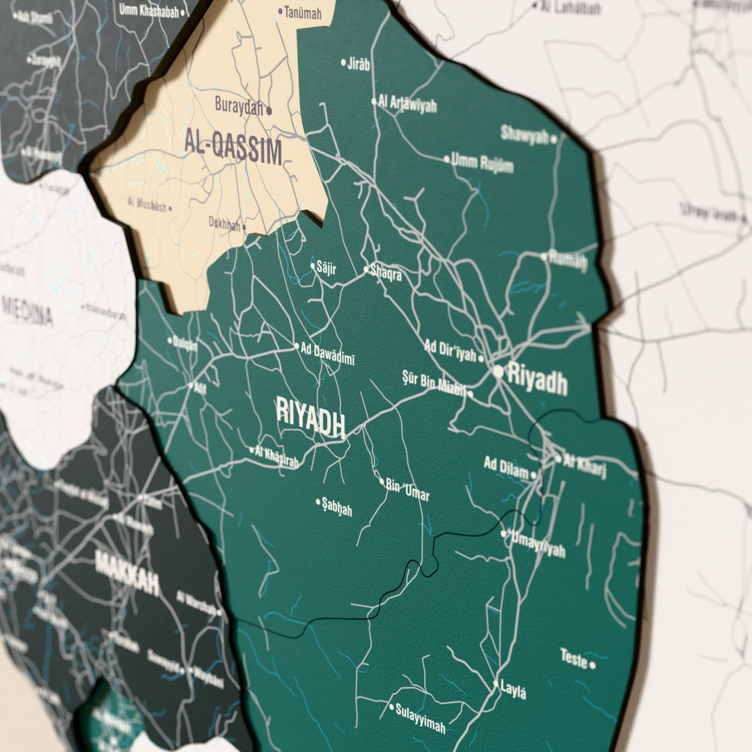 Suudi Arabistan ahşap haritasında bayrak renkli katmanlı bölgeler ve isimler, yakın plan