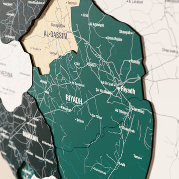 Suudi Arabistan ahşap haritasında bayrak renkli katmanlı bölgeler ve isimler, yakın plan