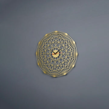 Altın Tesseract metal duvar saati, gri duvarda önden görünüm