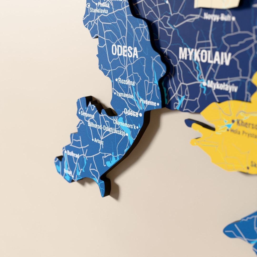 Ukrayna ahşap haritasında bayrak renkli katmanlı bölgeler ve isimler, yakın plan