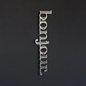 Bonjour yazılı dikey metal kapı süsü, Gümüş renk, koyu gri duvarda