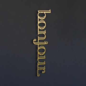 Bonjour yazılı metal duvar tablosu, Altın renk, koyu duvarda ortada