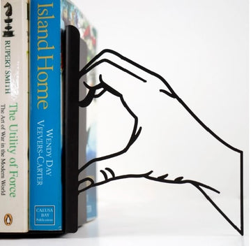Kalp şeklindeki el çizgili kitap tutucunun sağ parçası, kitapların yanında yakın çekim