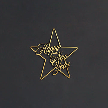 Altın renkli Happy New Year yazılı yıldız metal duvar dekoru, koyu gri duvarda karşıdan görünüm