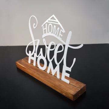 Beyaz Home Sweet Home metal masa dekoru, koyu kiraz renkli ahşap altlıkta yandan görünüm