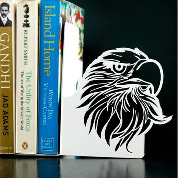 Beyaz metal kitap tutucudaki kartal başı oyma deseninin siyah fonda yakın çekimi