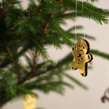 Çam dalından sarkan altın renkli zencefilli kurabiye şeklinde Noel ağacı süsü yakın çekim